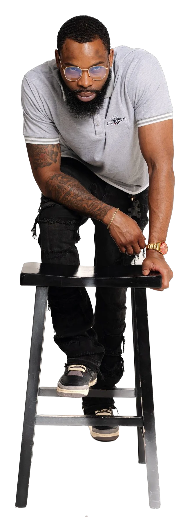 Man leaning on a stool in a grey Lone Wolves polo